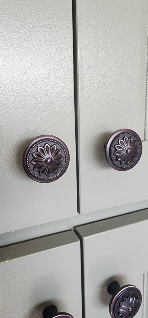 green cabinets with bronze hardware knobs