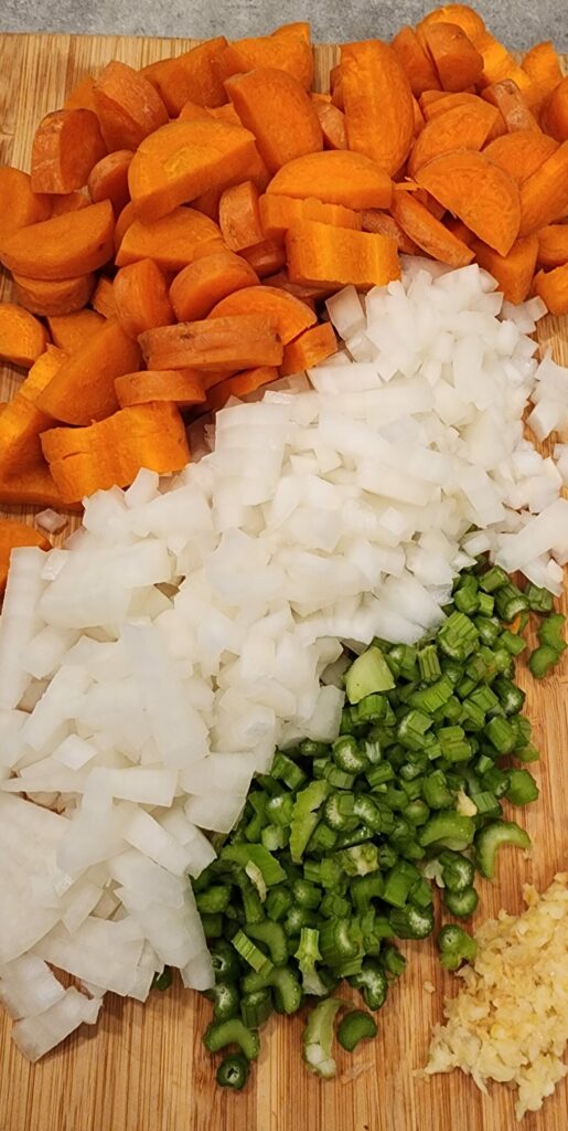 chopped carrots onions and celery on cutting board