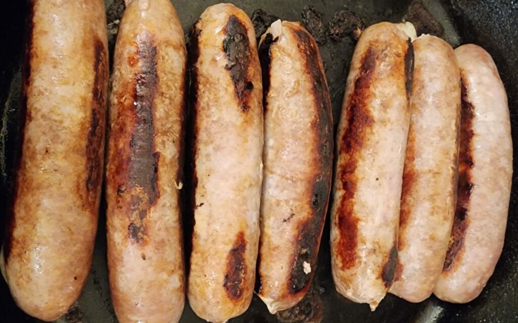 cooked sausages in a cast iron pan