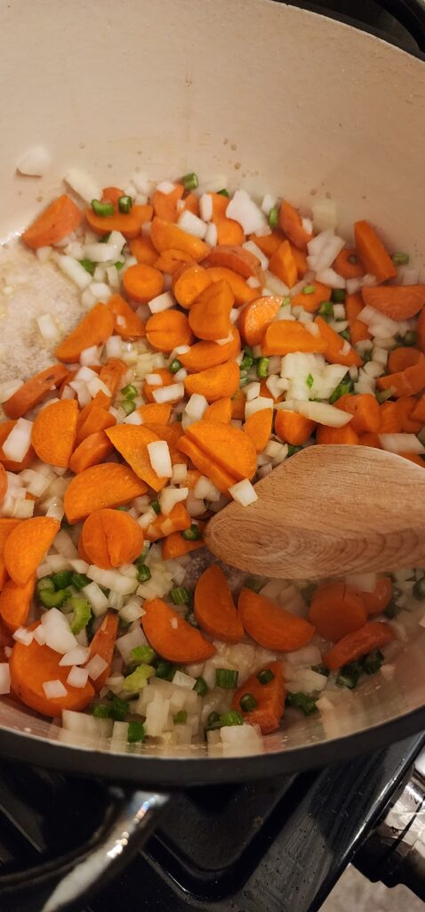 carrots, onions, and celery cooking in a pan