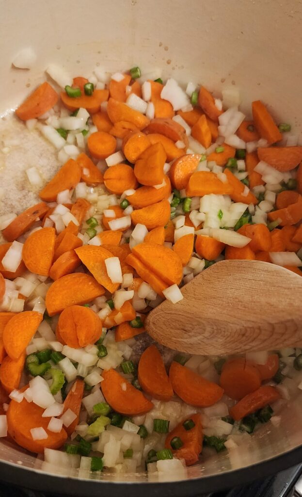 carrots, onions, and celery cooking in a pan