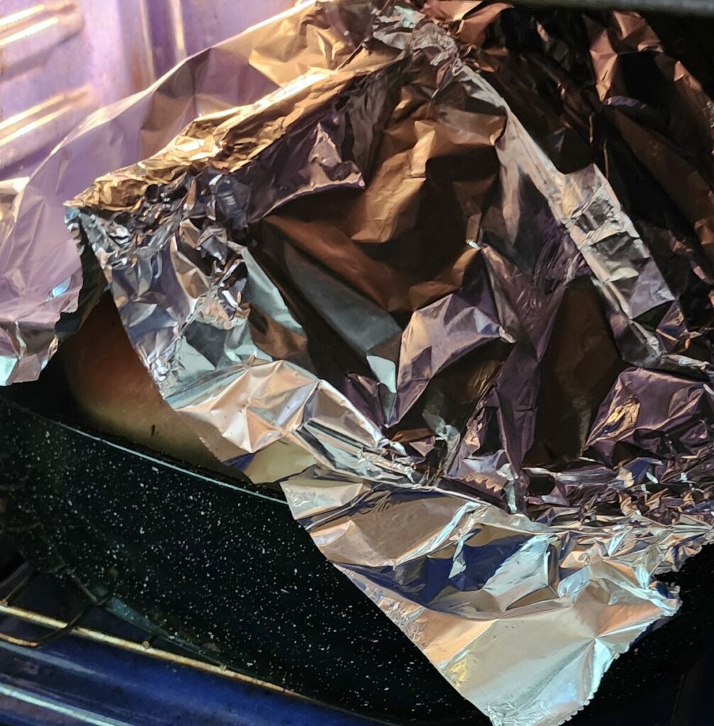 roasting turkey tented with aluminum foil