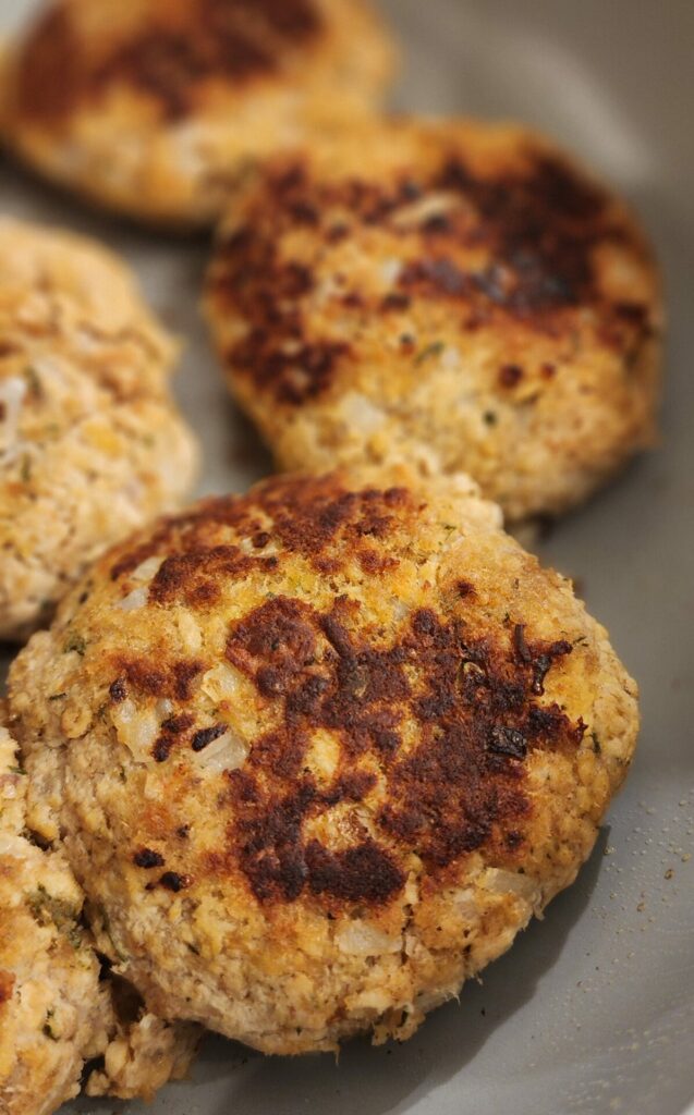 salmon cakes cooking in skillet