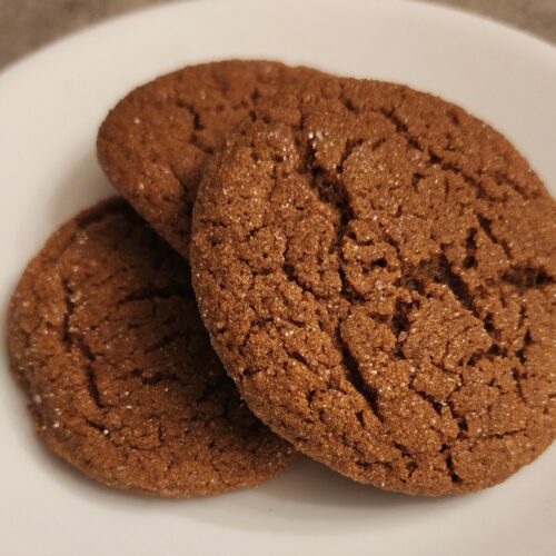 three ginger molasses cookies on a plate