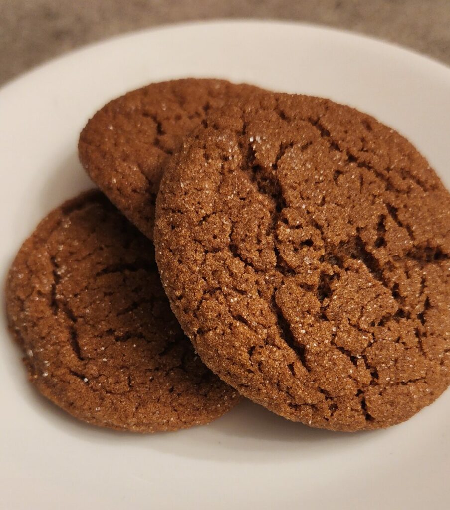 three ginger molasses cookies on a plate
